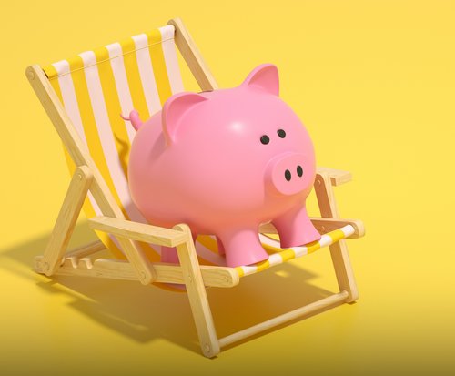 Ein rosafarbenes Sparschwein auf einem gelb-weiß gestreiften Liegestuhl als Symbolbild für eine Bonuszahlung.
